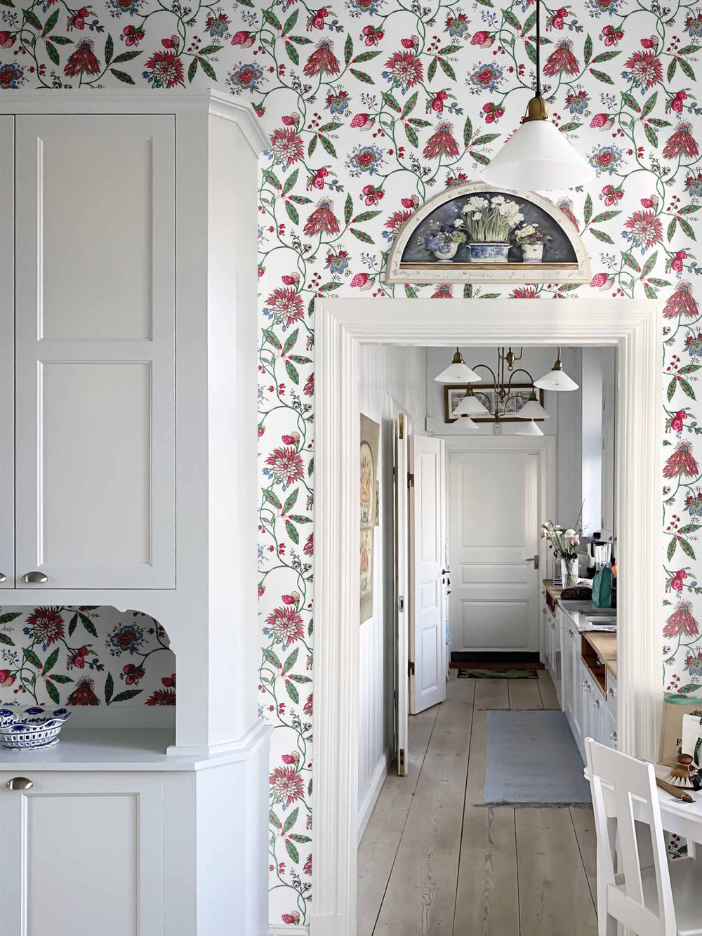 A dark pink and green vintage inspired floral wallpaper in a home interior
