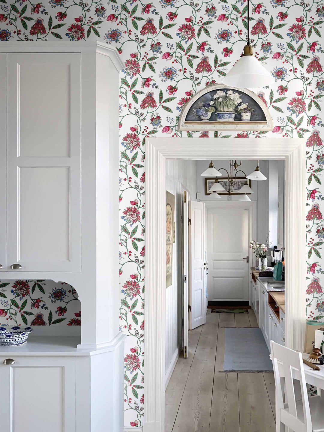 A dark pink and green vintage inspired floral wallpaper in a home interior
