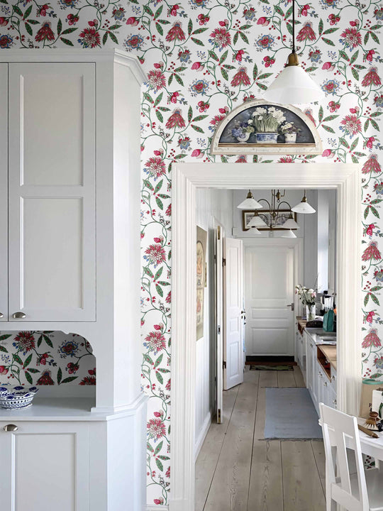 A dark pink and green vintage inspired floral wallpaper in a home interior