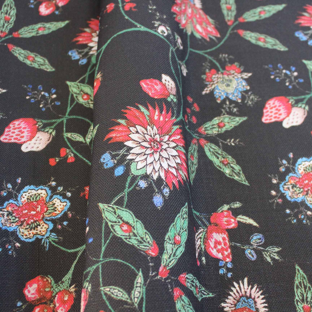 Amalita Floral Fabric featuring vibrant flowers and leaves in pink, green, and blue on a black background, perfect for upholstery.