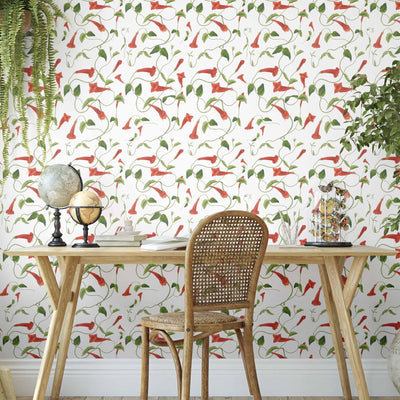 An interior with a red and green trailing floral wallpaper featuring fed firecraker flowers and leaves. resulting in a fresh, yet warm interior design.