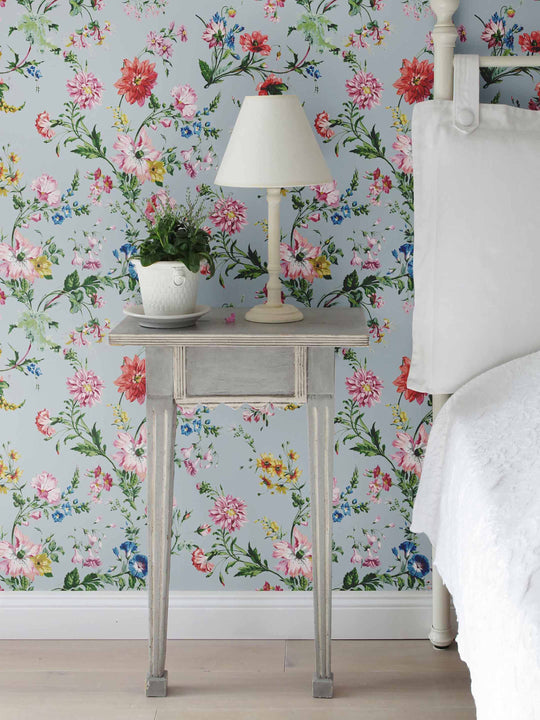 Bedroom with a ale blue wallpaper featuring pink, yellow and blue flowers