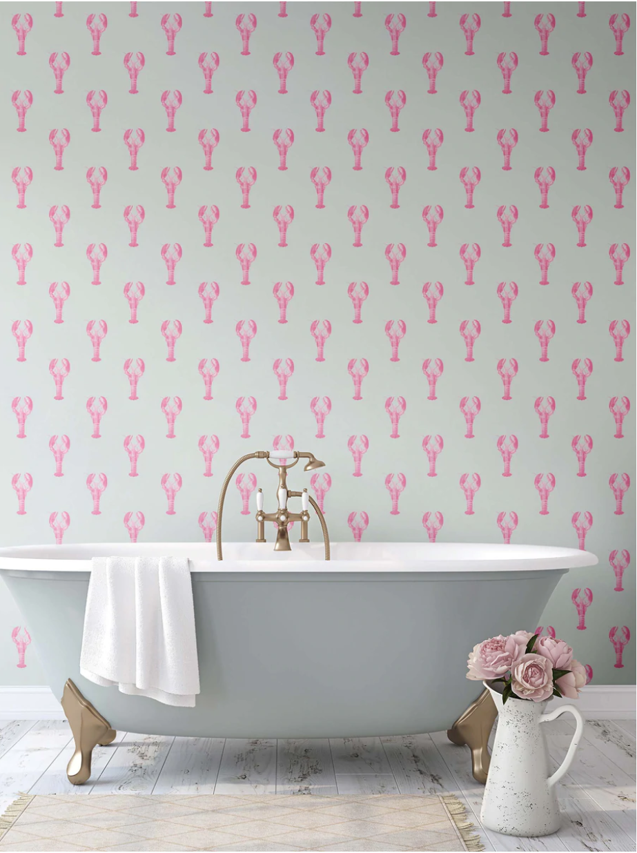 Bathroom with a freestanding bathtub against a wall with pink lobster patterned wallpaper