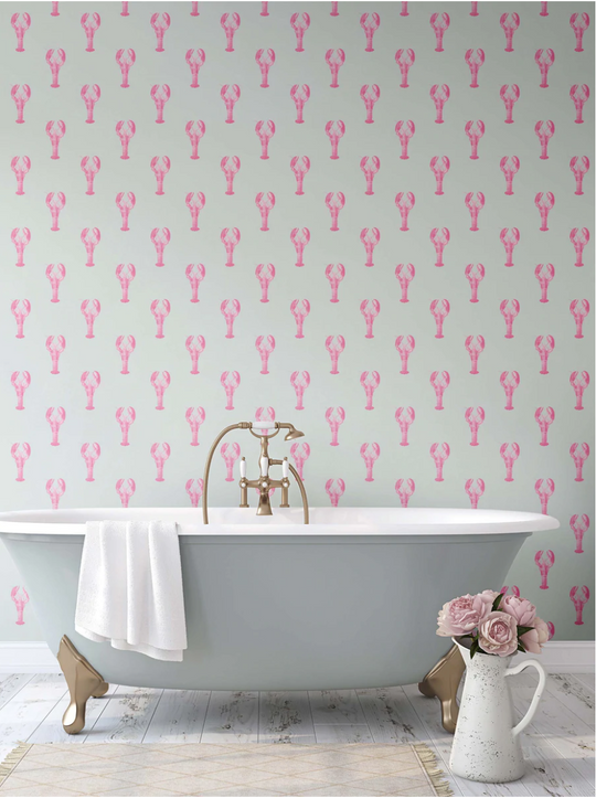 Bathroom with a freestanding bathtub against a wall with pink lobster patterned wallpaper