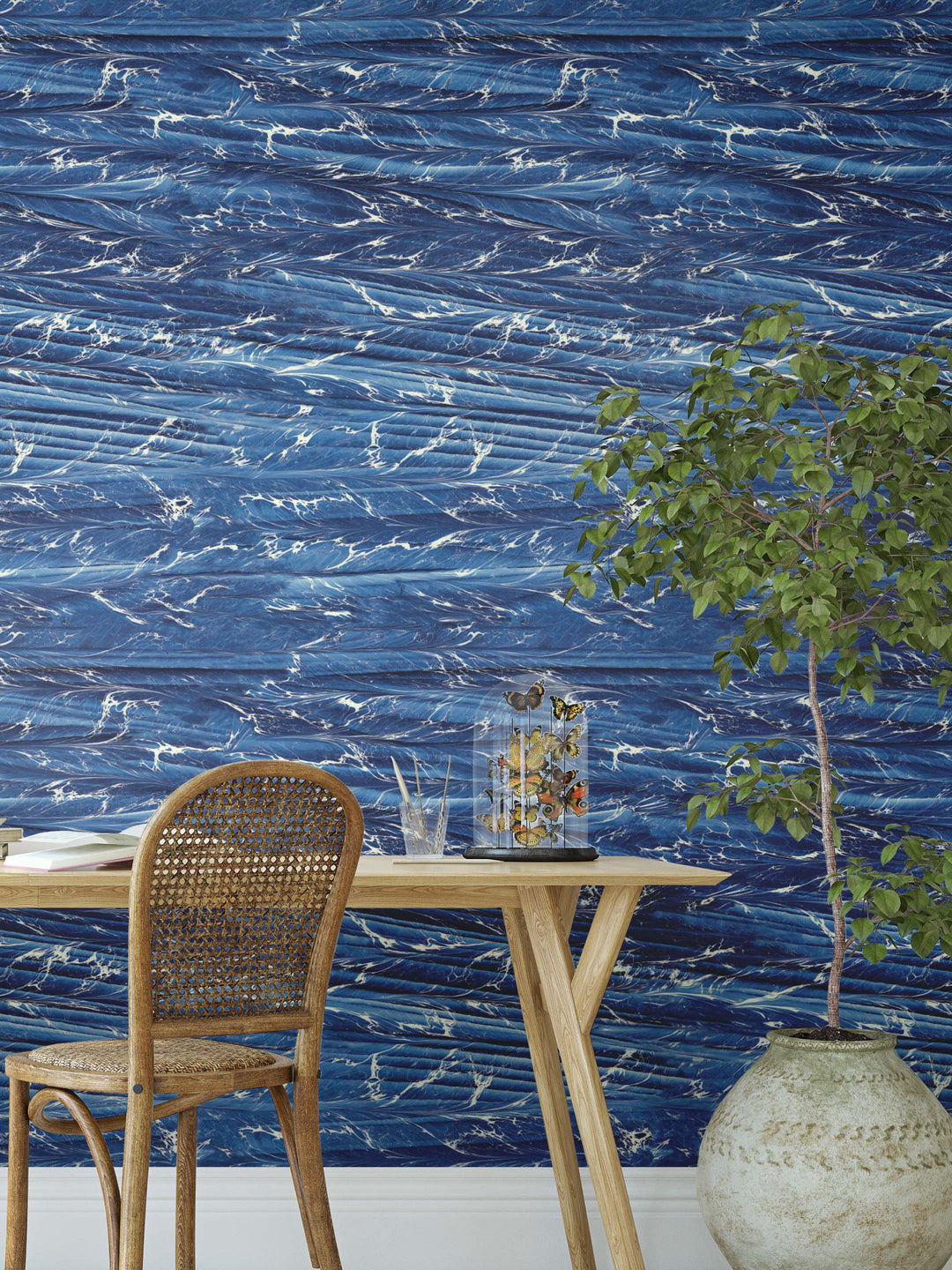 A statement marbled wallpaper in dark blue decorating a wall behind a desk