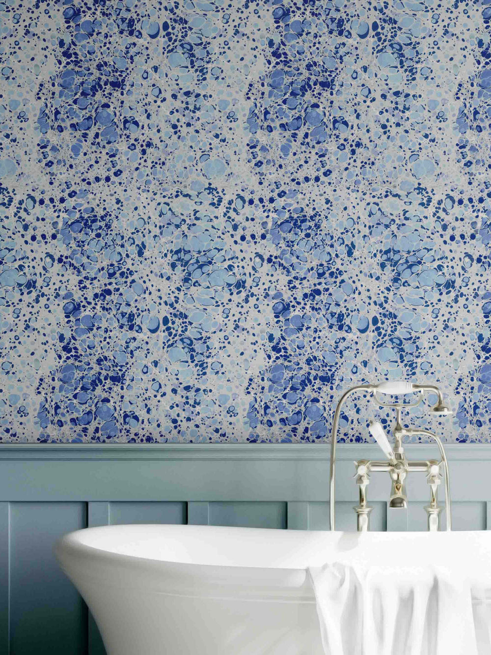A wallpaper with a blue marbled pattern, displayed on a wall above a bathtub.