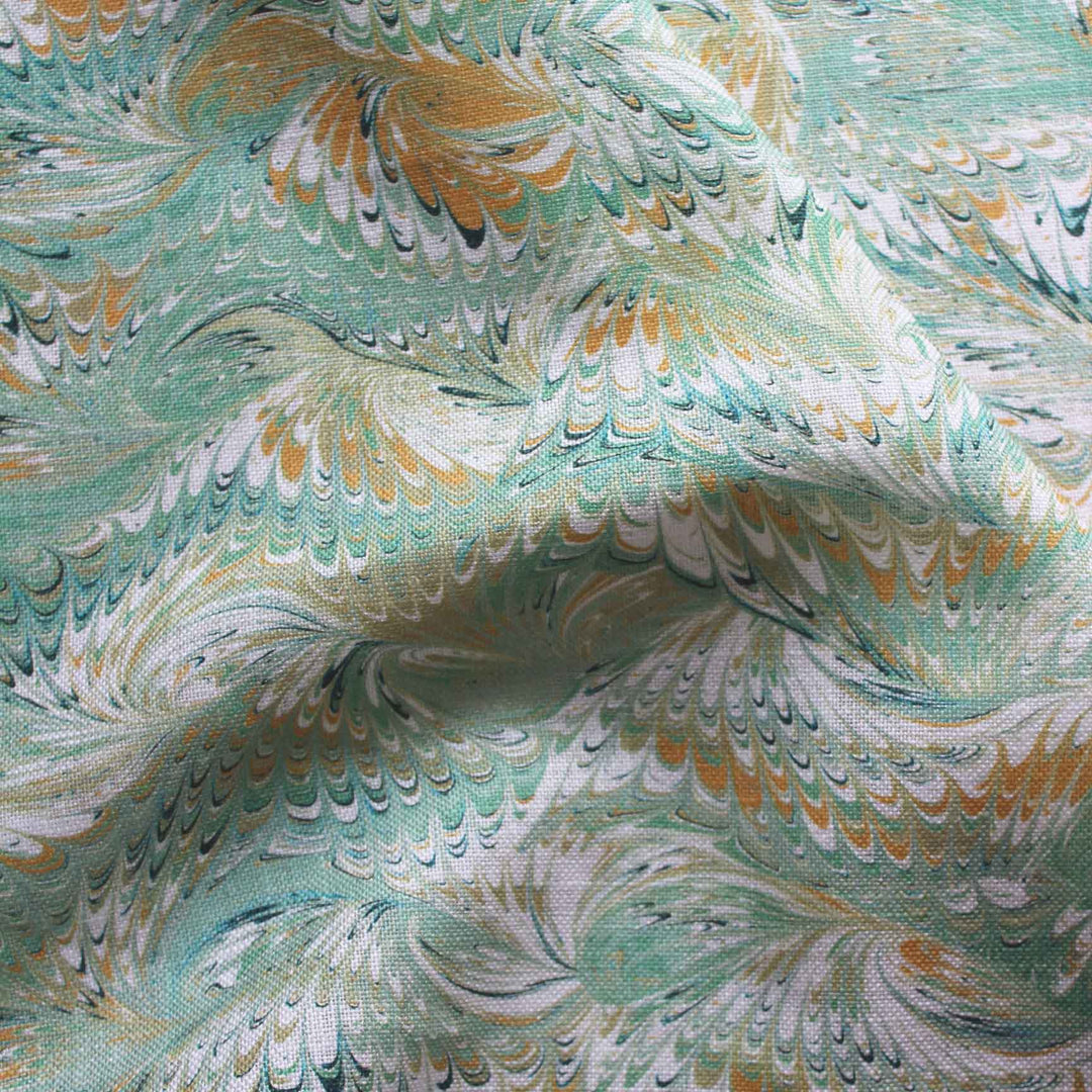 A soft green marbled printed fabric with marblized swirls of yellow, dark blue and white. Suitable fabric for curtains, Blinds and sift furnishings