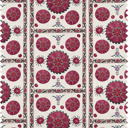 Paris Suzani fabric featuring intricate floral and geometric patterns in dark pinks, teal greens on an off-white background.