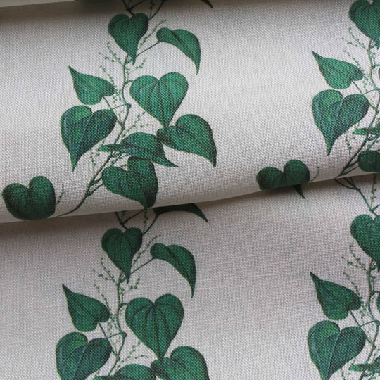 Linen curtain fabric featuring trailng green vine leaves on a off white background by Milola Design.