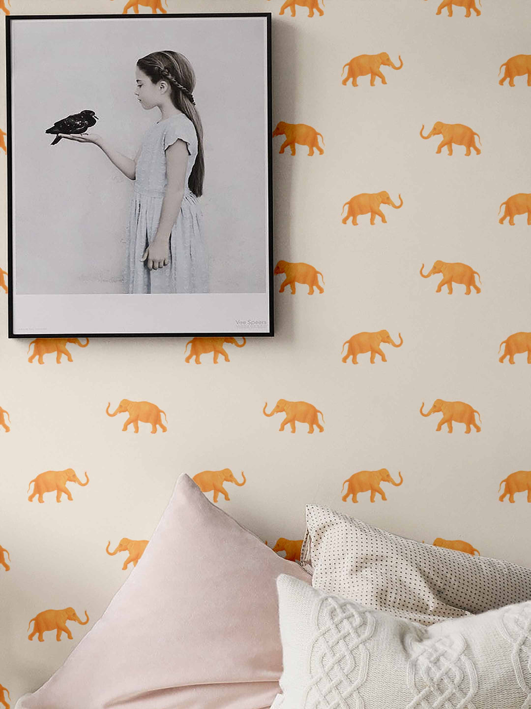 Orange elephant wallpaper with a cream background on a bedroom wall