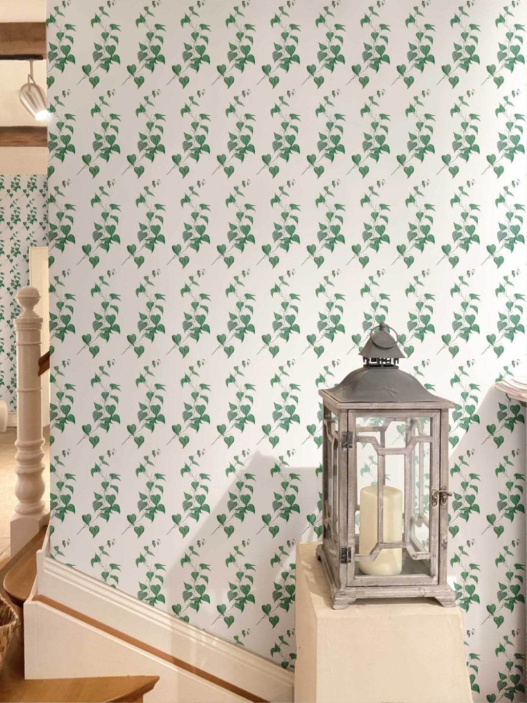 A wall adorned with green leafy vine wallpaper, featuring a pattern of vines climbing up the wall. 