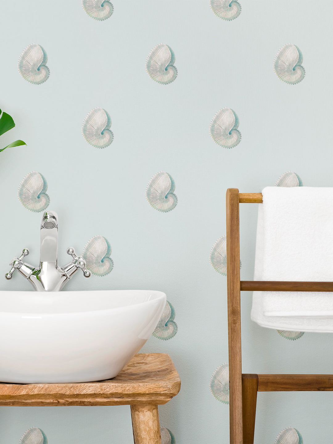 A pale blue sea shell wallpaper shown in a bathroom. Argonaut wallpaper by Milola Design